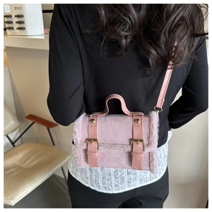 Detailansicht der rosa Plüsch-Umhängetasche mit Zierschnallen und Metallbeschlägen im Nahformat