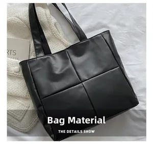 Detail of black quilted tote bag with glossy finish and dual shoulder straps