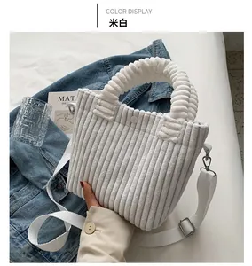 Detail of off-white corduroy tote bag with ruffled handles and adjustable shoulder strap