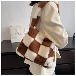 Detail of soft brown and white checkered plush shoulder bag with metal brand tag