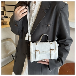 Detail der weißen Plüsch-Leder-Umhängetasche mit goldfarbenen Metallschnallen