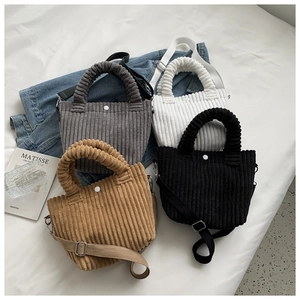 Detailed display of corduroy bucket bags in four colors with adjustable shoulder straps