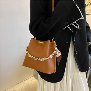 Sac seau vintage marron avec foulard léopard porté par un mannequin de profil