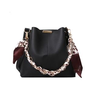 Sac seau noir classique avec détails dorés et bandoulière élégante avec foulard léopard