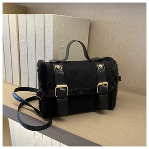 Nahaufnahme der schwarzen Plüschtasche mit Kunstpelzbesatz und goldenen Schnallen-Details