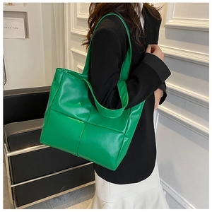 Macro detail of grass green woven faux leather tote bag with thick strap and soft texture
