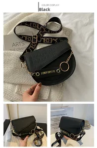 Details der schwarzen Satteltasche aus Kunstleder mit Krokoprägung und Goldkette