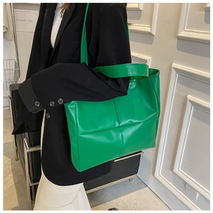 Macro detail of large green tote bag with quilted square stitching and soft PU leather texture