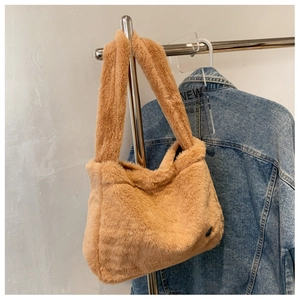 Close-up of fluffy brown plush tote bag with visible soft faux fur texture and brand label