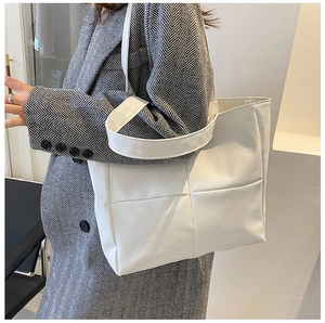 White woven tote bag shown on a model with minimalist grid pattern design