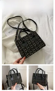 Dettaglio borsa a tracolla in tweed nero e oro con trama intrecciata e manici