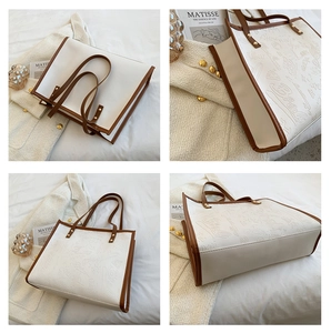 Detail of white tote bag with brown leather straps and embossed graffiti patterns