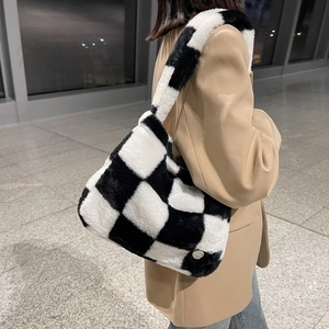 Chic black and white checkerboard plush shoulder bag styled with a neutral blazer