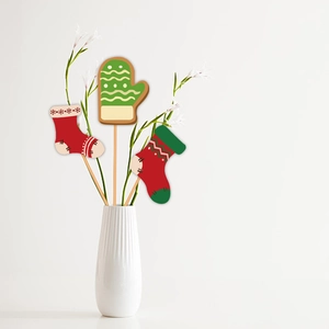 Christmas themed vase picks featuring festive red socks and green glove paper decorations