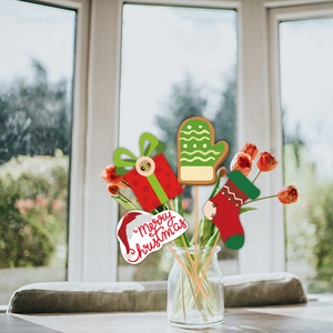Festive Christmas cake toppers featuring socks and gloves used as floral vase decoration