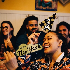 Detail of New Year photo props featuring Happy New Year signs and gold party hats