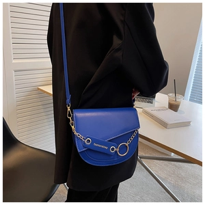 Detail of dark blue PU leather saddle bag with gold chain and fashion lettering