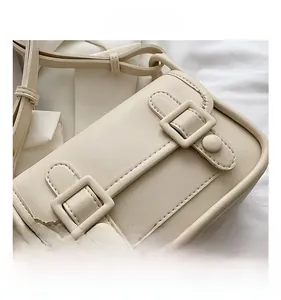Detail view of cream PU leather square crossbody bag with vintage double buckle design