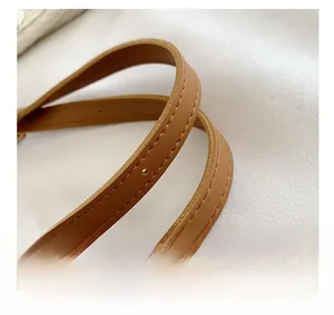 Close-up of adjustable brown leather shoulder strap with durable double stitching detail
