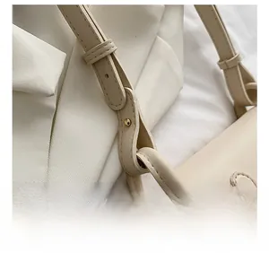 Macro shot of strap connection with metal rivets and stitching on beige shoulder bag