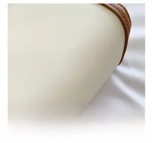Detailed macro view of the cream leather fabric and brown stitched edge of the bucket bag
