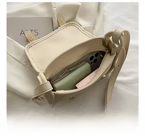 Interior view of small off-white square bag showing capacity for phone and wallet