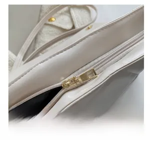 Détail du zip métallique doré fluide sur le sac à bandoulière en cuir blanc