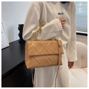 Détail du sac bandoulière matelassé beige avec chaîne dorée et texture en similicuir chic