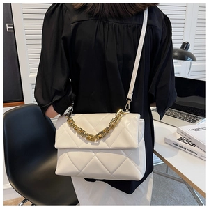 Détail du sac bandoulière matelassé blanc avec chaîne dorée et fermeture à rabat