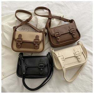 Flat lay of vintage crossbody square bags in black, brown, and khaki with double buckle straps