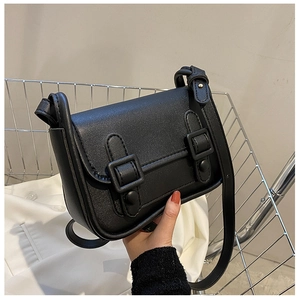 Detail of a vintage black square crossbody bag with dual buckles and matte PU texture