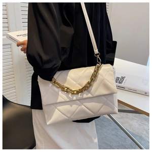 Gros plan d'un sac à bandoulière en cuir blanc matelassé avec grosse chaîne dorée