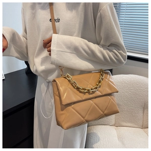 Détail du sac bandoulière matelassé chameau avec poignée chaîne dorée et rabat