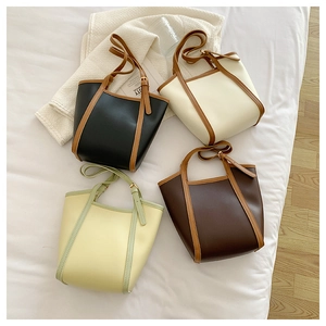 Flat lay of four contrasting color PU leather tote bags in black, cream, brown, and green