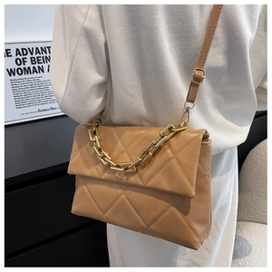 Sac bandoulière matelassé avec chaîne dorée porté à l'épaule pour un style quotidien