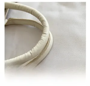 Detail of soft cream-colored padded PU leather handle on woven canvas tote bag