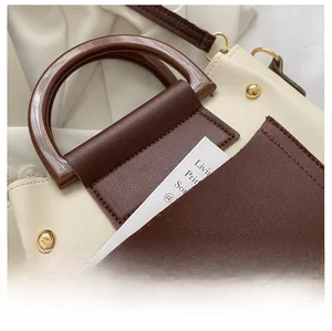 Detailed macro view of the two-tone Boston bag front pocket and circular handle