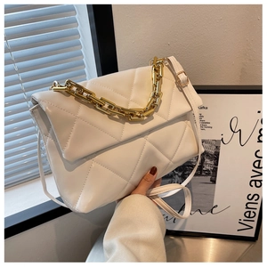 Gros plan du sac à main blanc matelassé avec poignée en chaîne dorée et bandoulière en cuir