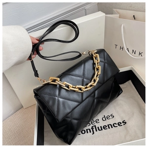 Détail du sac matelassé noir avec chaîne dorée et emballage cadeau de luxe élégant