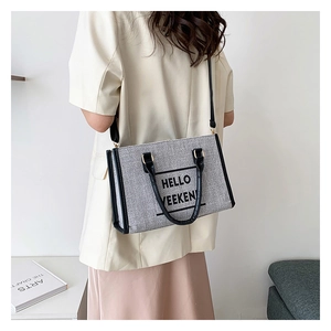 Canvas tote bag with Hello Weekend print worn by model against a minimalist background