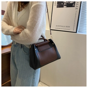 Side view of woman carrying a contrast-color minimalist shoulder bag in a modern setting