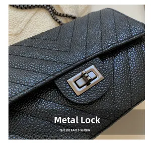 Close-up of a black caviar leather crossbody bag featuring a V-quilted pattern and metal lock