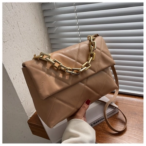 Détail du sac bandoulière en cuir matelassé beige avec poignée chaîne dorée et rabat