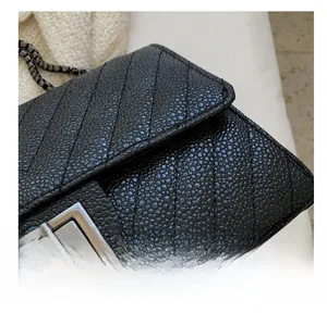 Detail view of black pebble leather texture with chevron stitching and vintage metal clasp