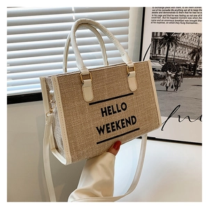Detail of Hello Weekend canvas tote bag with leather straps in soft natural sunlight