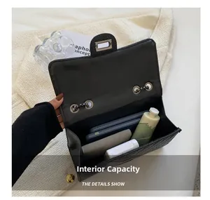Internal capacity of black quilted chain bag showing space for phone and wallet
