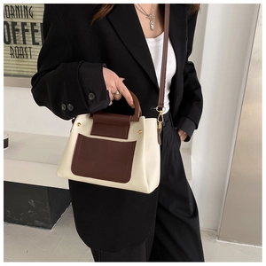 Detail of contrast bucket bag with wooden handle and adjustable leather shoulder strap