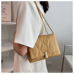 Vue détaillée du sac à bandoulière matelassé beige avec chaîne dorée et fermoir métal