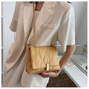Détail du sac bandoulière matelassé jaune avec chaîne dorée et motif de surpiqûres