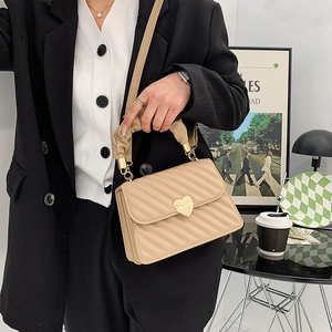 Bolso bandolera beige acolchado con cierre de corazón dorado y asa fruncida elegante
